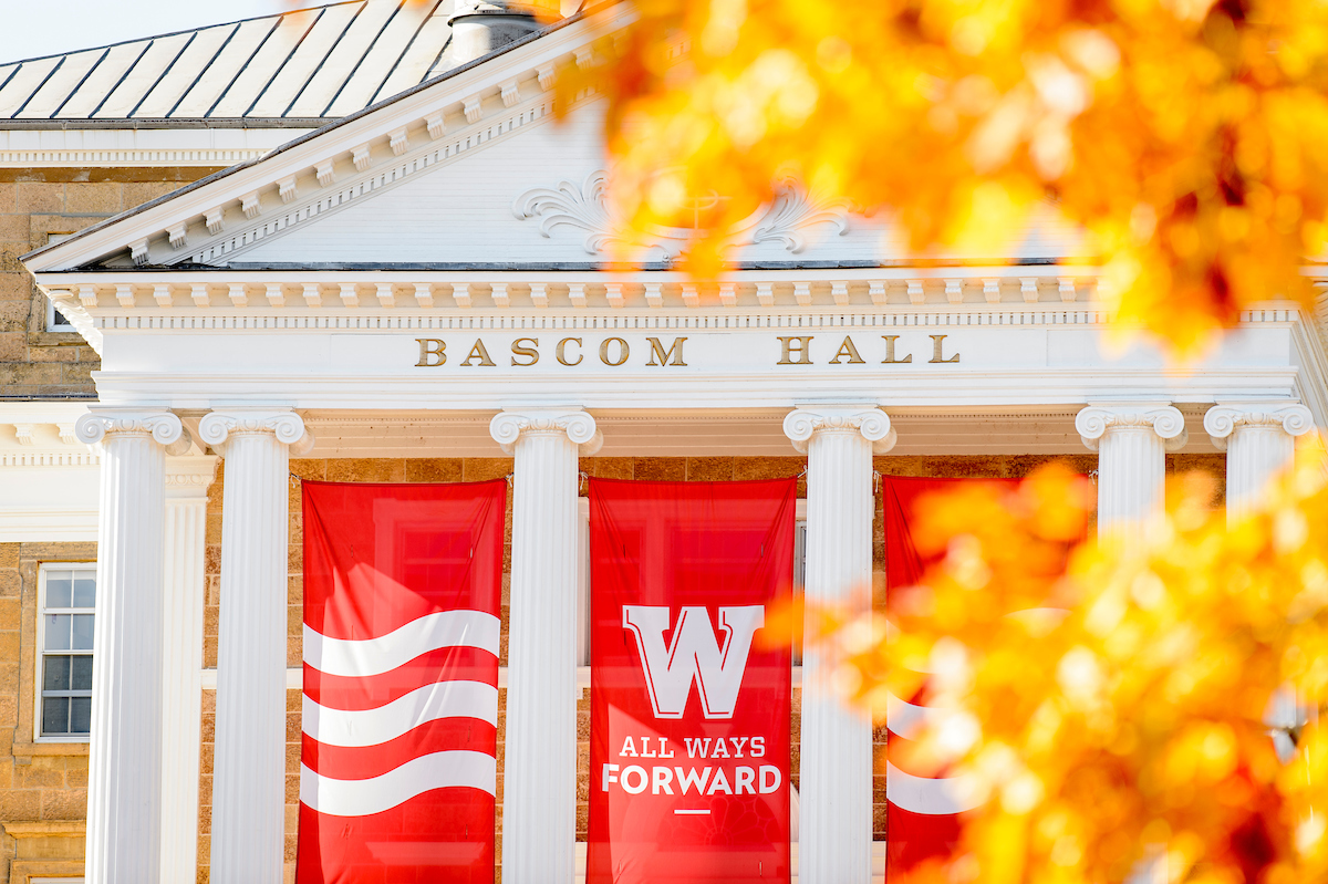 Picture of W campaign banner on Bascom Hall framed by golden leaves