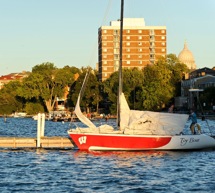 A UW Hoofer sailboat on lake Mendota during the sunset.