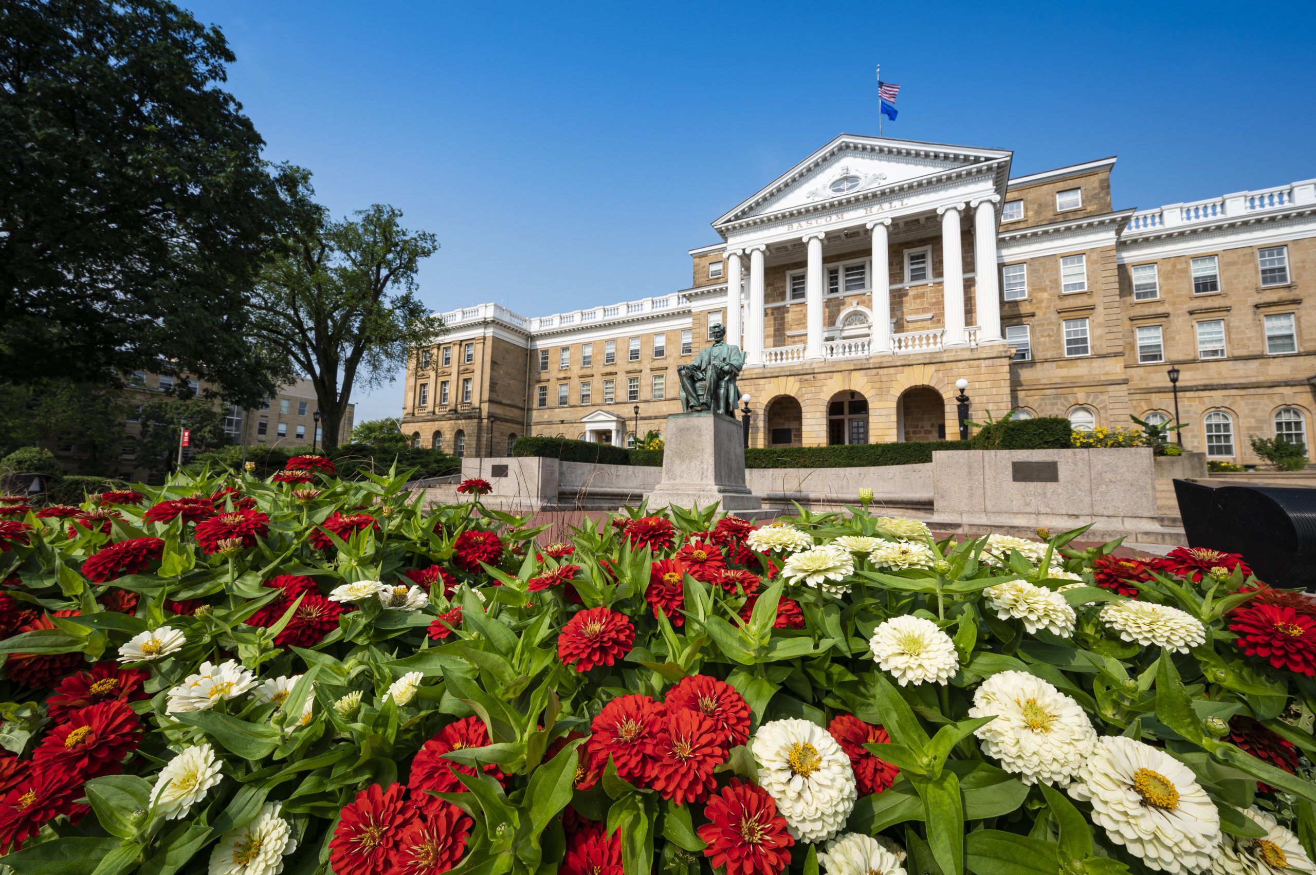 Bascom Hall with red and white flowers in front.