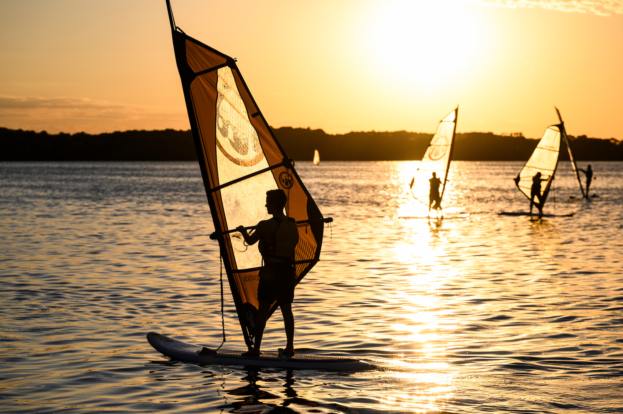 Wind surfer on lake with sunset